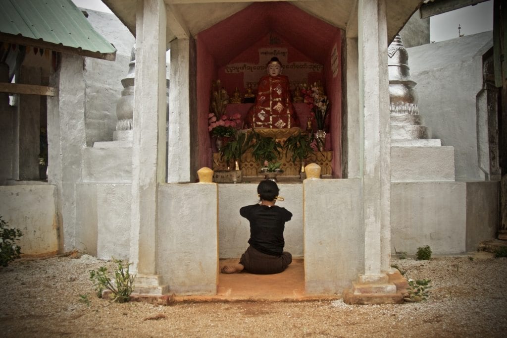 Woman prays before Buddha, Say Kinn, Burma