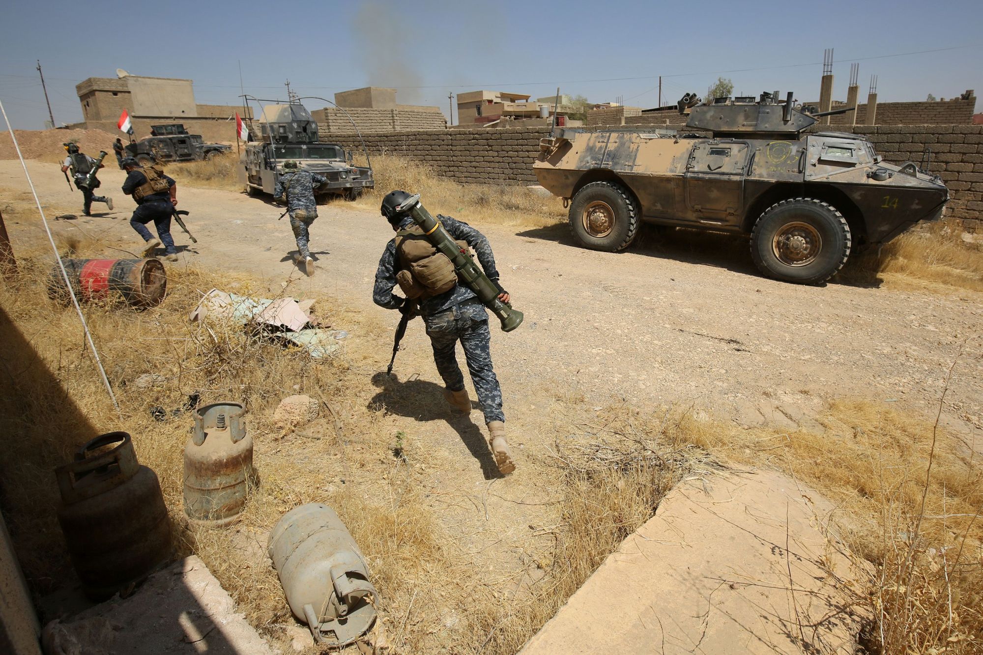 Image Iraqi forces, backed by the Hashed al-Shaabi (Popular Mobilisation units), advance through Tal Afar's al-Wahda district during an operation to retake the city from the Islamic State (IS) group on August 24, 2017. (AFP PHOTO / AHMAD AL-RUBAYE)