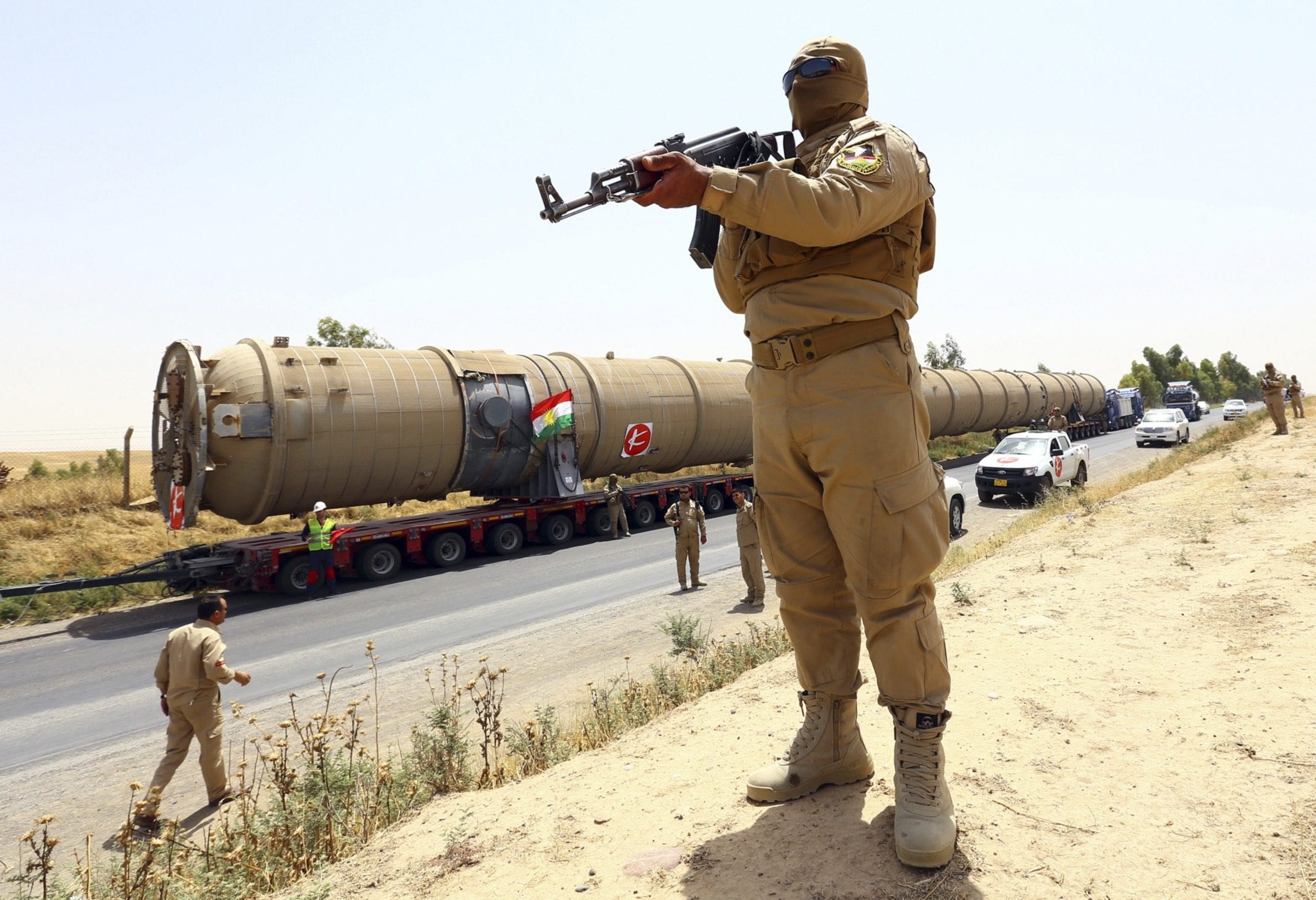 Image A member of the Kurdish security forces takes up position with his weapon as he guards a section of an oil refinery, which is being brought on a truck to Kalak refinery in the outskirts of Arbil, in Iraq's Kurdistan region, July 14, 2014. (REUTERS/Stringer)