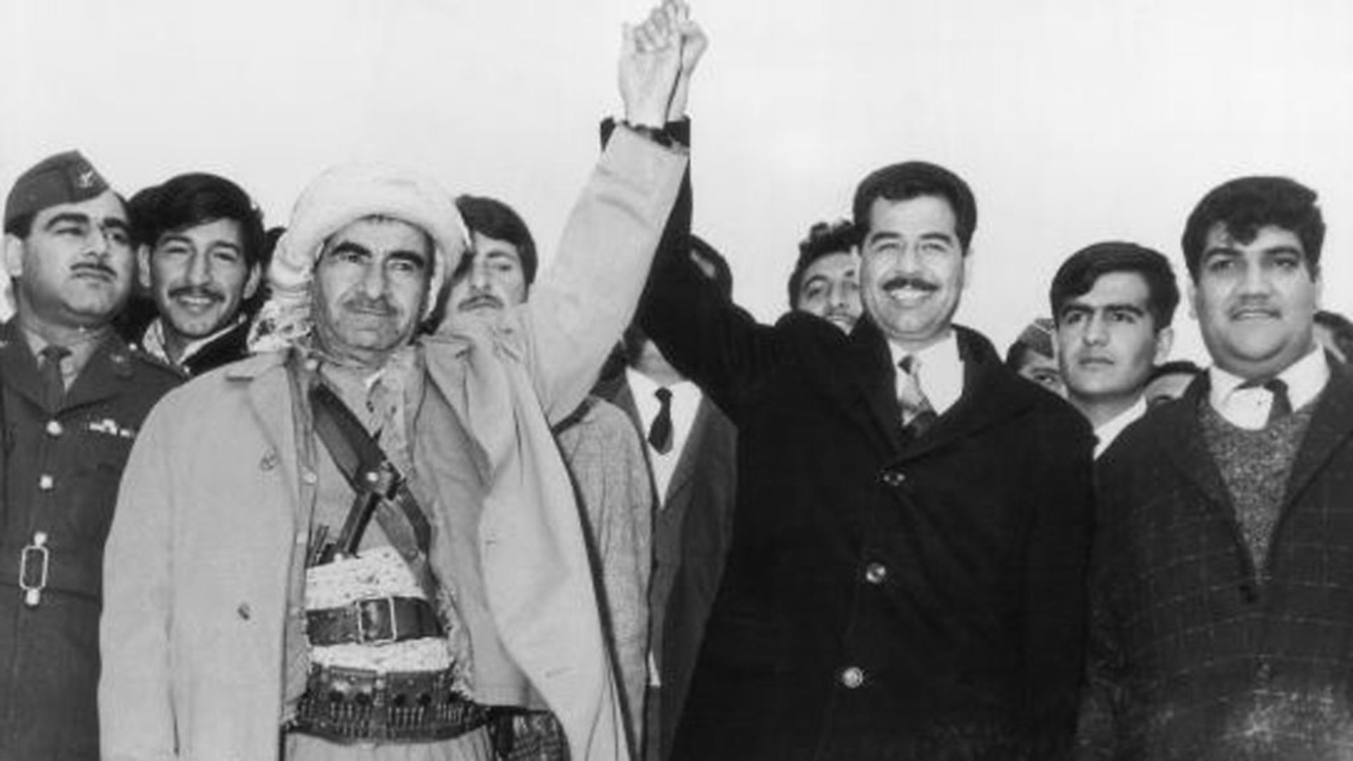 Image Mulla Mustafa Barzani, leader of the Kurdistan Democratic Party, holds hands with Saddam Hussein (BBC)