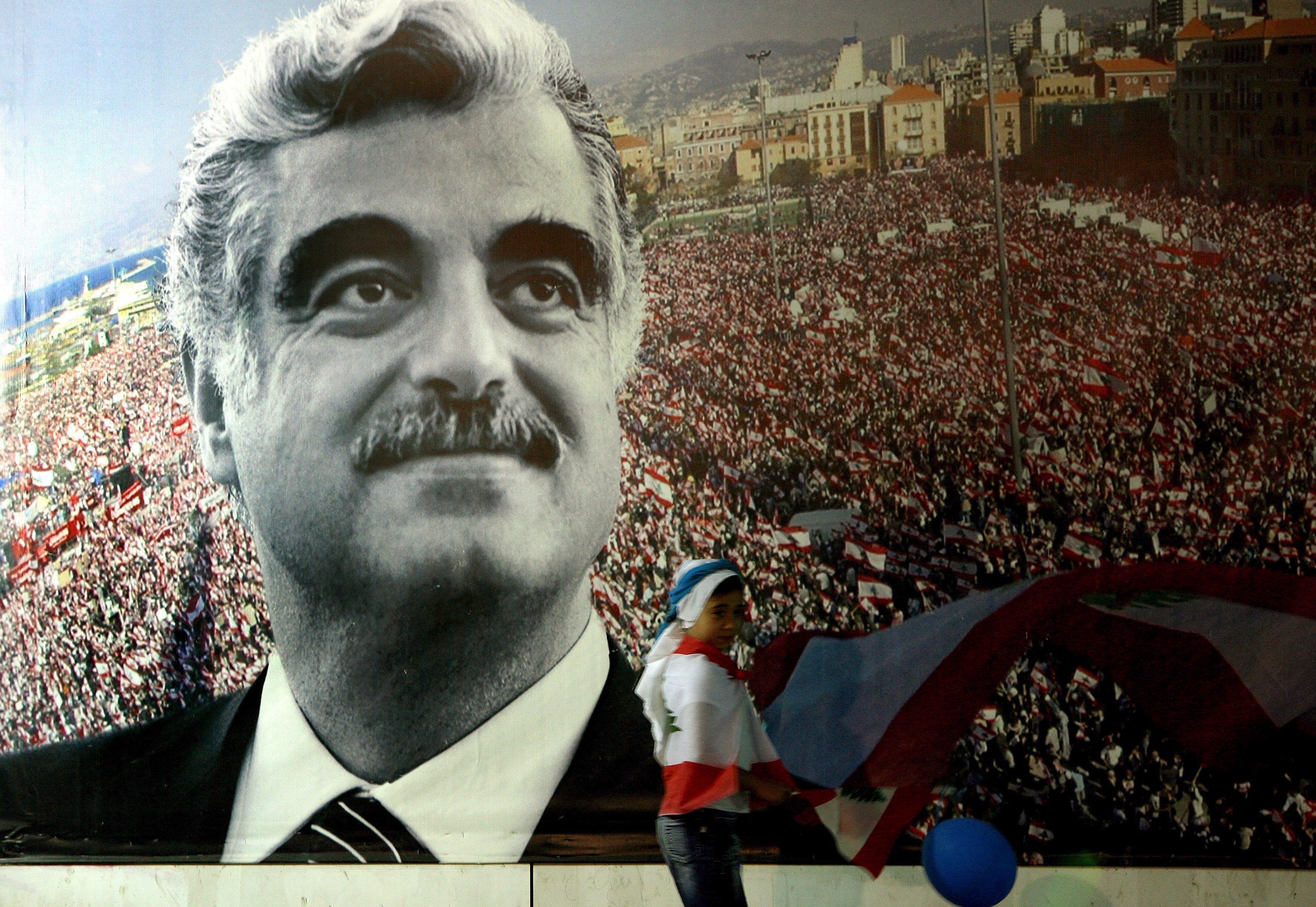 Image A Lebanese girl waves a flag in front of a giant poster of slain former Lebanese premier Rafik Hariri near his grave in central Beirut on 30 May 2007. (EPA/NABIL MOUNZER)