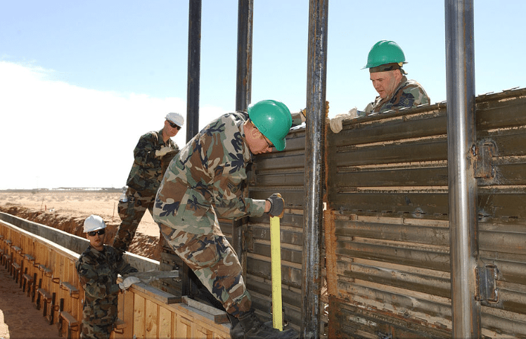 Image (US Air Force Tech Sgt. Gordy Haldmenn and Senior Airman Daniel Bones (right to left) assist in the 2007 Operation Jump Start by building fence sections along the Mexican border. | Source: US Air Force)