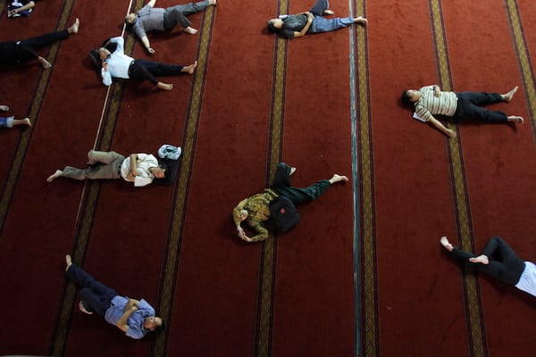 Image Indonesian Muslim men sleep as they wait for the time to break their fast at Istiqlal Mosque in Jakarta, Indonesia, on July 23. (Tatan Syuflana/Associated Press)