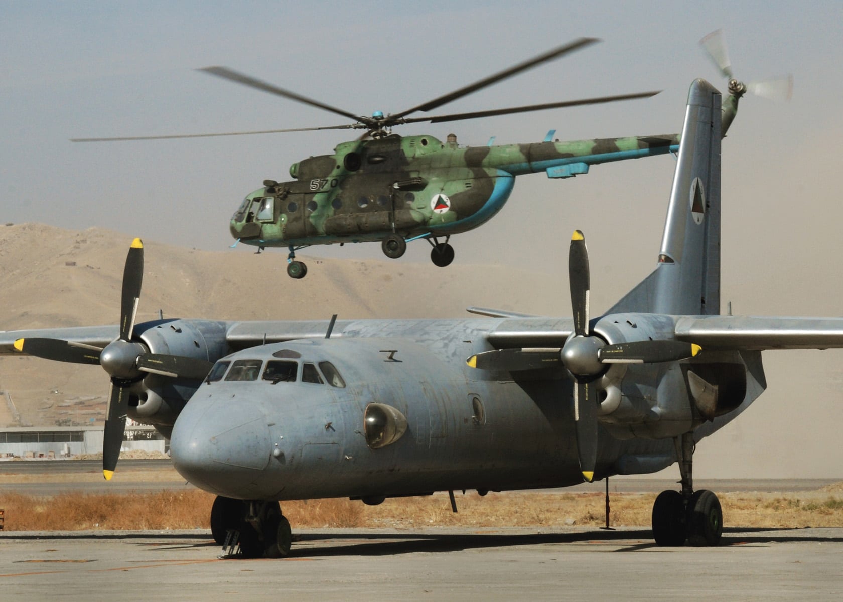 Image An Afghan national army air corps MI-17 takes off past an AN-26 at the Kabul Air Base, Afghanistan [Image: Petty Officer 1st Class David M. Votroubek, US Navy].