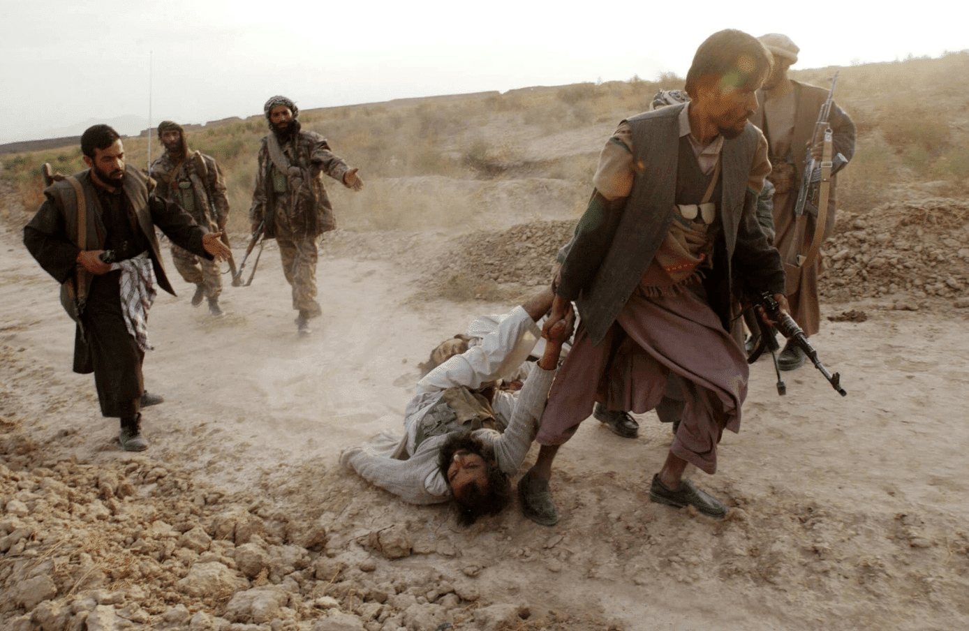 Image Northern Alliance soldiers dragging a captured ISIS fighter during their advance on Kabul in 2001. (James Hill)