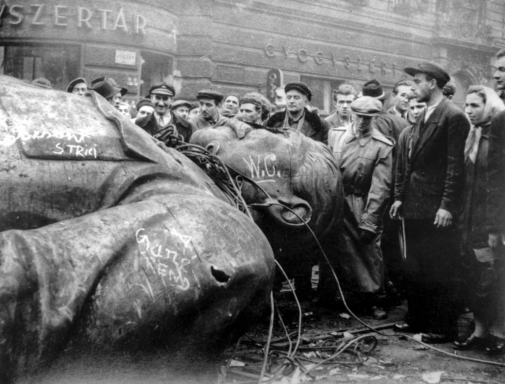 Image [Oct. 24, 1956, people gather around a fallen statue of Soviet leader Josef Stalin in front of the National Theater in Budapest, Hungary. The uprising in Hungary began on Oct. 23, 1956 with demonstrations against the Stalinist regime in Budapest and was crushed eleven days later by Soviet tanks amid bitter fighting. (AP Photo / Arpad Hazafi)