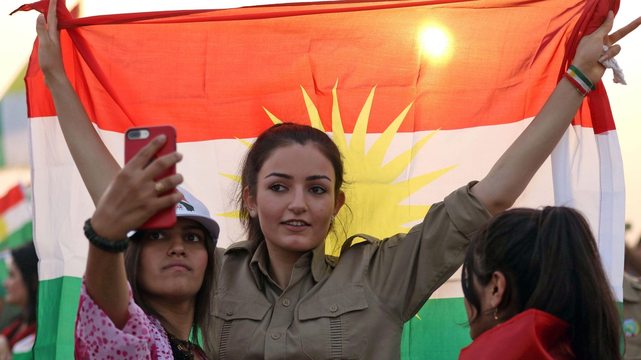 Image [An Iranian Kurdish woman holds a Kurdish flag as she takes part in a gathering before the Iraqi Kurdistan independence referendum, which was held on September 25, 2017. (AFP)]