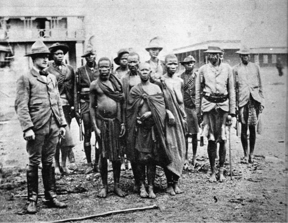 Image [Nehanda Mbuya (center) with soldiers and a British officer.]