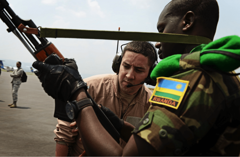 Image [U.S. soldier examines a weapon before allowing the soldier, and 850 other Rwandan soldiers, to board a U.S. Air Force plane in route to the Central African Republic to aid French and African Union operations. (U.S. Air Force photo/ Staff Sgt. Ryan Crane)]