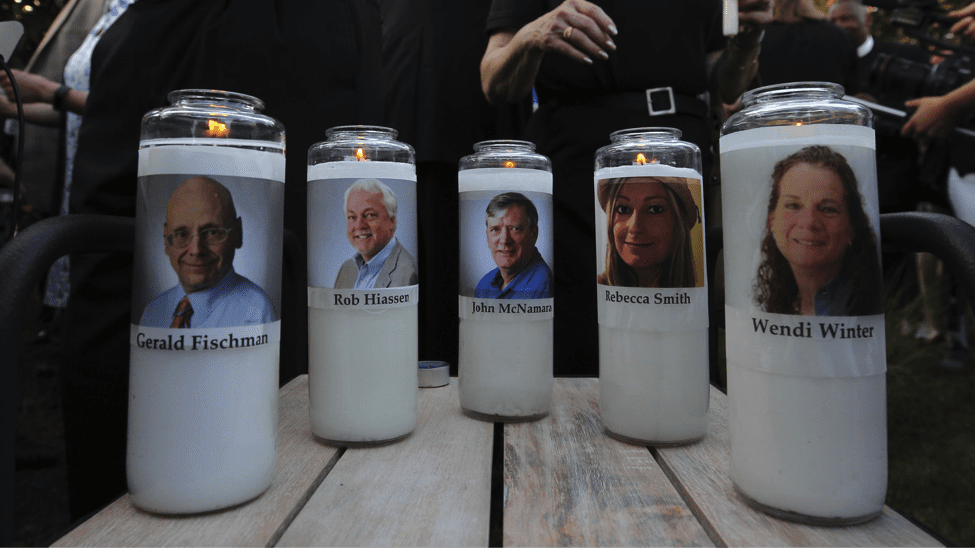 Image The photos of five murdered Capital Gazette employees adorn candles at a vigil in June in Maryland. (Jose Luis Magana)