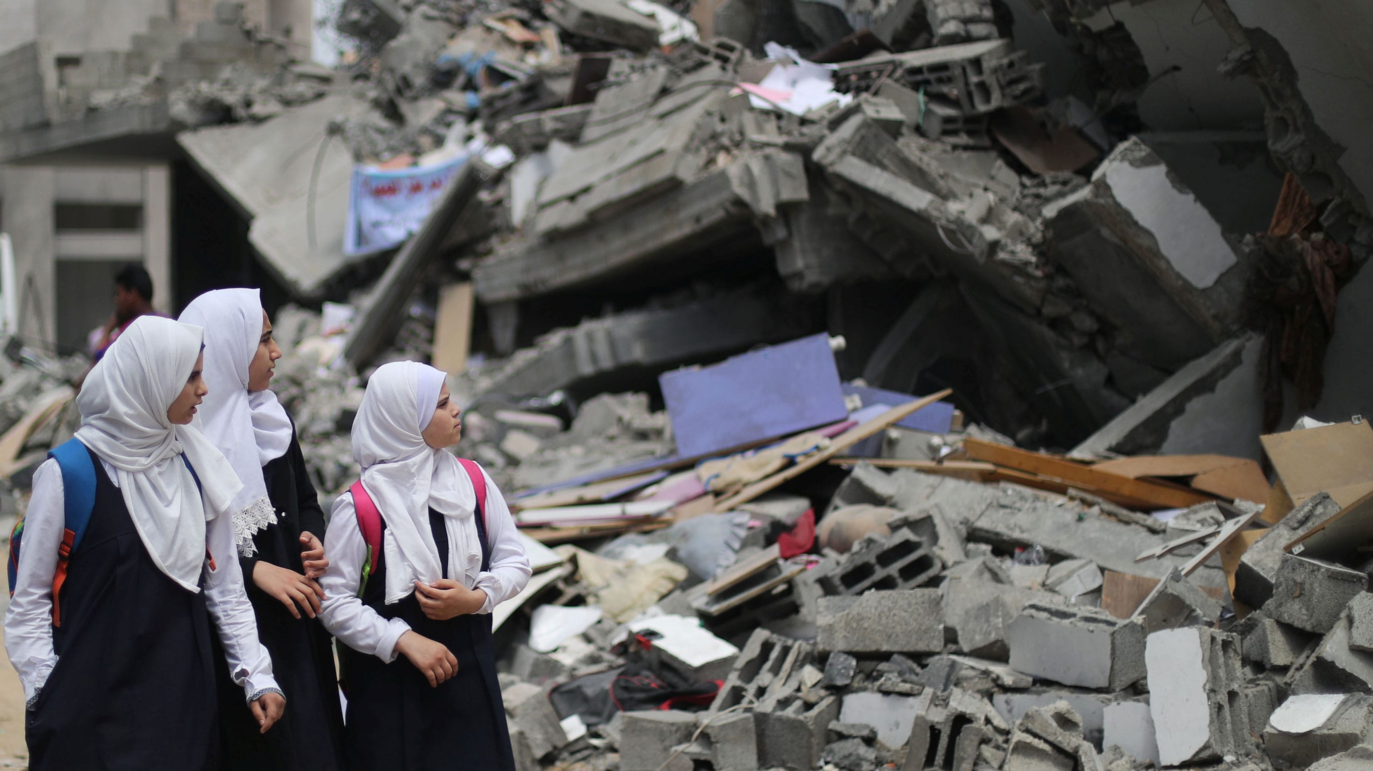 Palestinian students look at a building that was destroyed by Israeli airstrikes near their damaged school in Gaza City, Gaza, May 7, 2019. (Photo: Mohammed Salem / Reuters)]